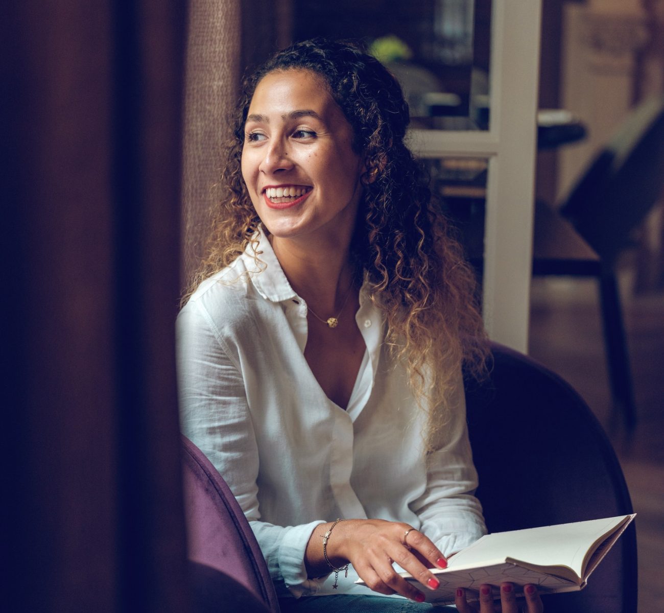 cheerful-ethnic-woman-reading-book-in-cafe.jpg